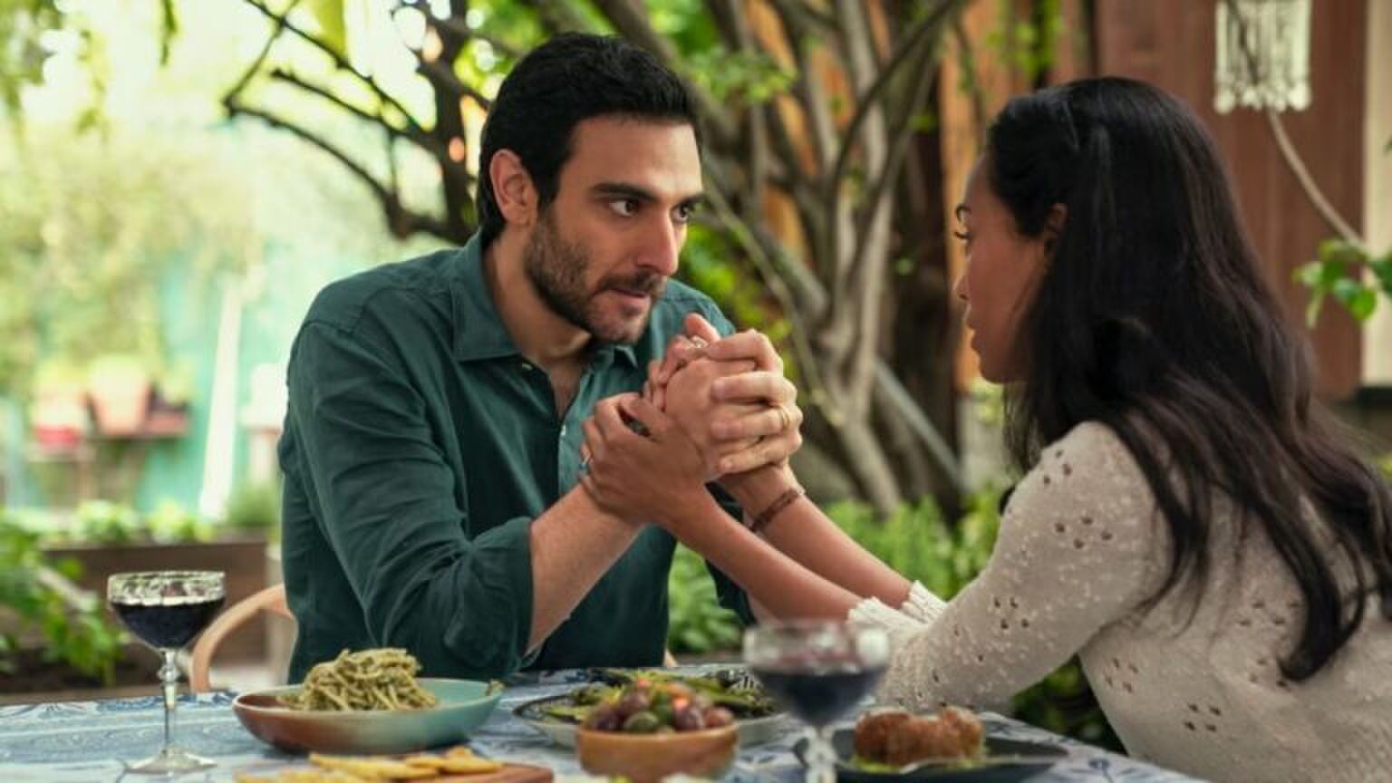 Een koppel zit tegenover elkaar aan tafel.