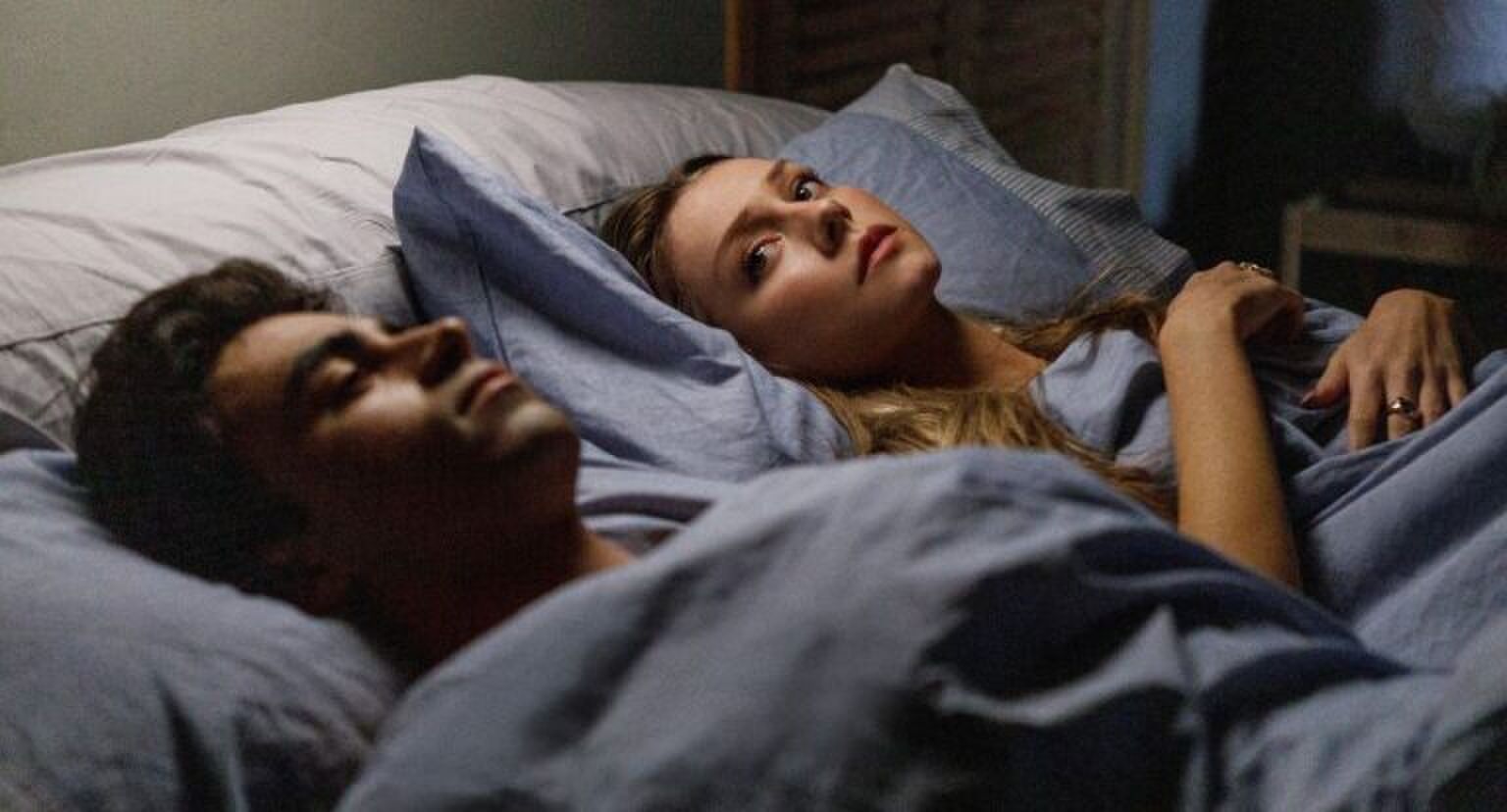 Twee mensen liggen samen in bed.