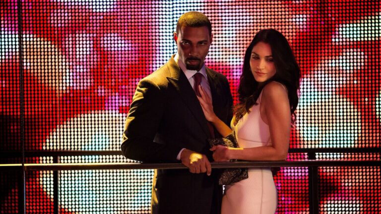 Een man en vrouw kijken neer vanaf een balkon.