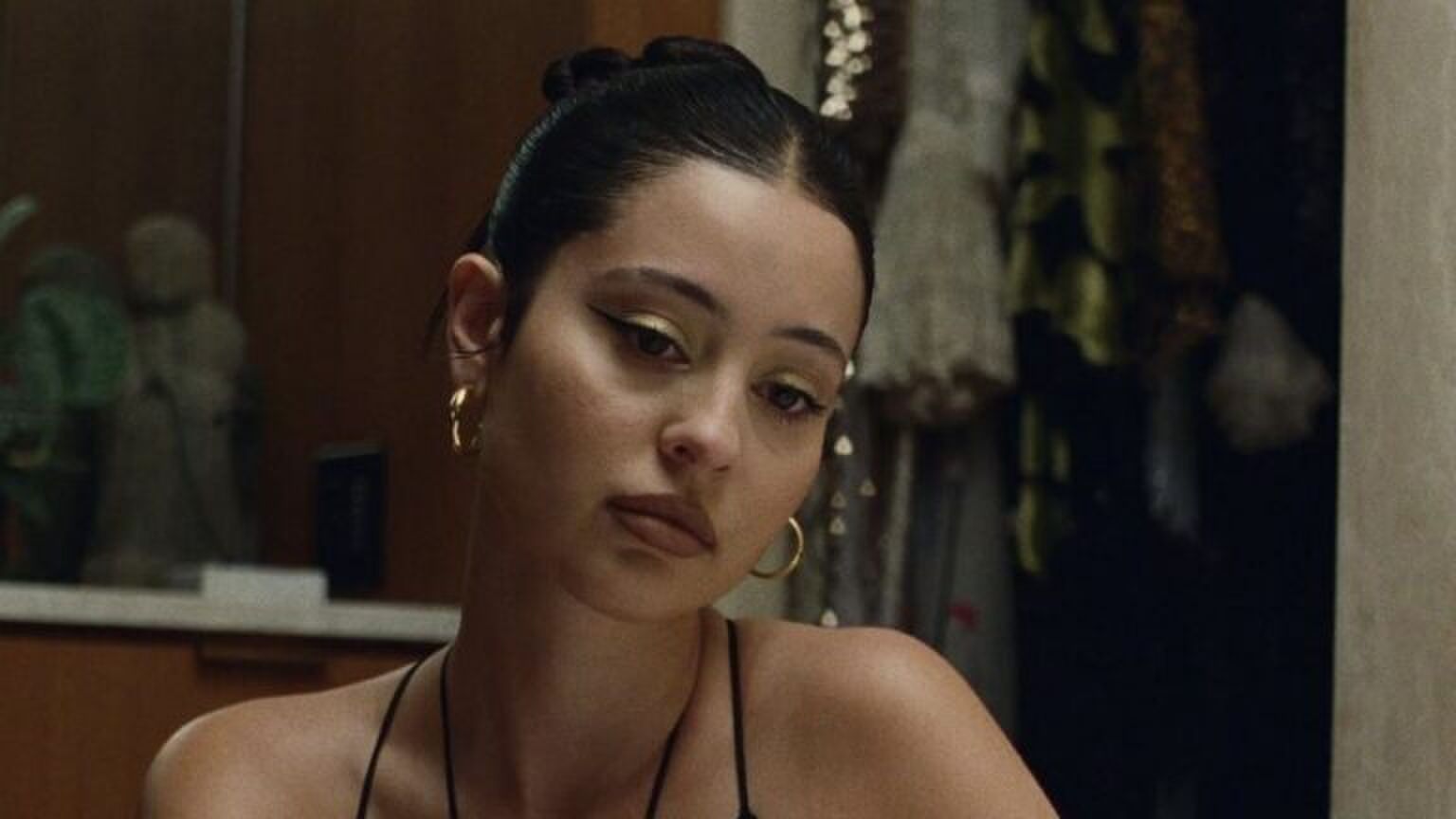 Foto van Maddy Perez in Euphoria. Ze kijkt verdrietig met haar ogen teneergeslagen.