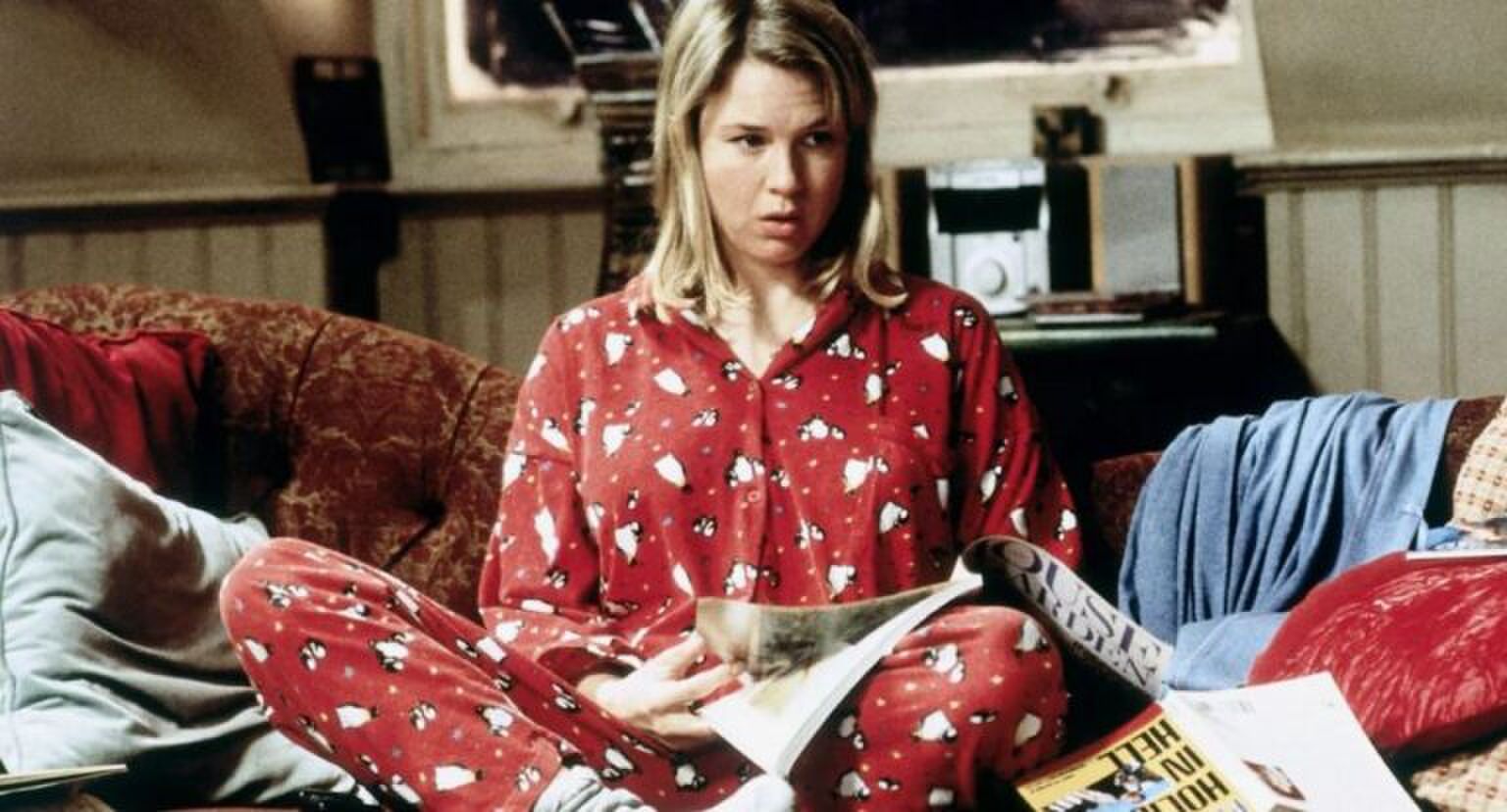 Meisje zit in pyjama op de bank.