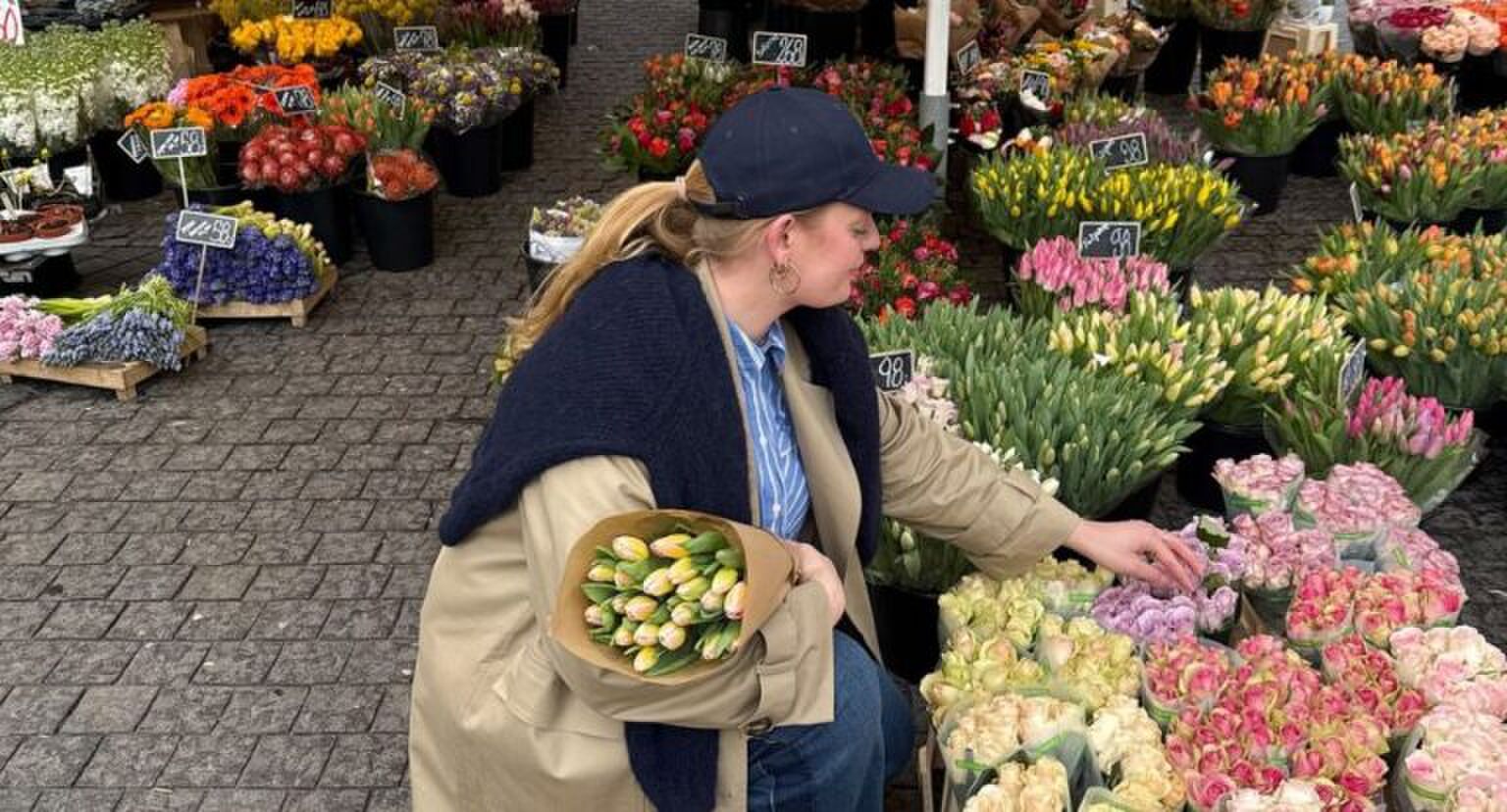 meisje gehurkt bij bloemenkraam