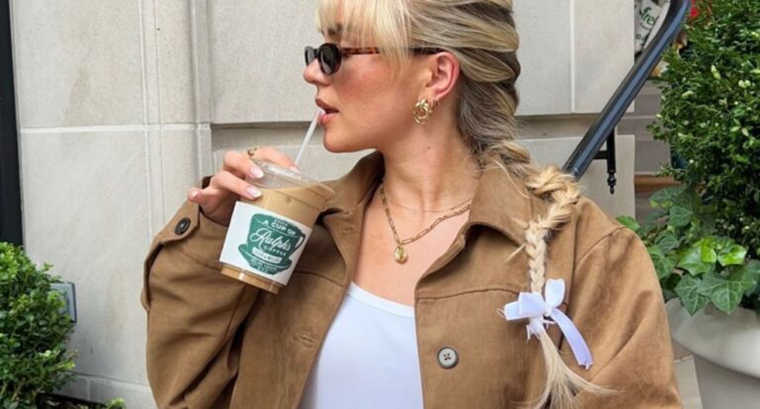 blond meisje drinkt een beker ijskoffie