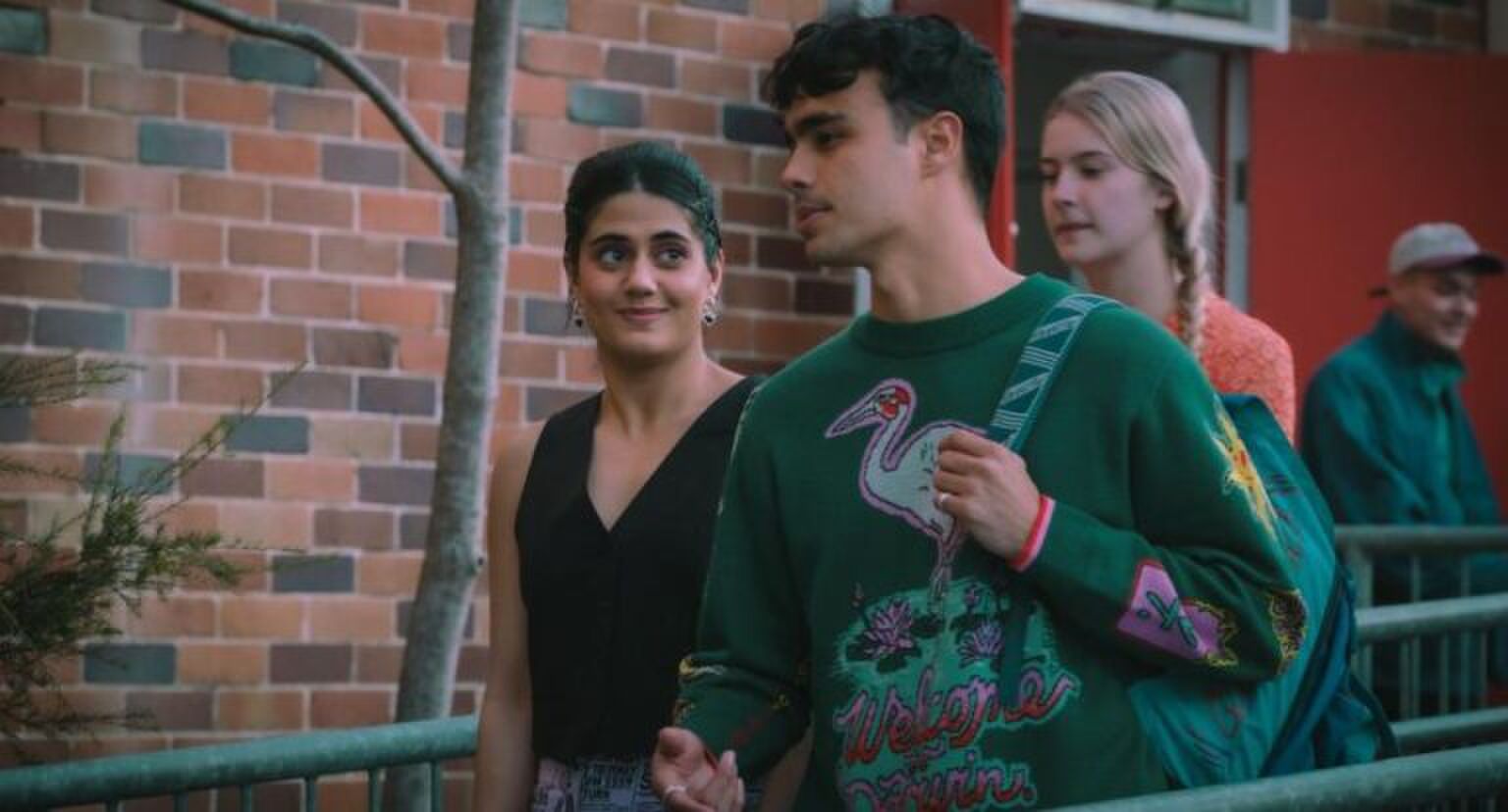 Sc&egrave;ne uit Heartbreak High waarin Amerie en Malakai samen over het schoolplein lopen. Amerie kijkt verliefd naar Malakai.