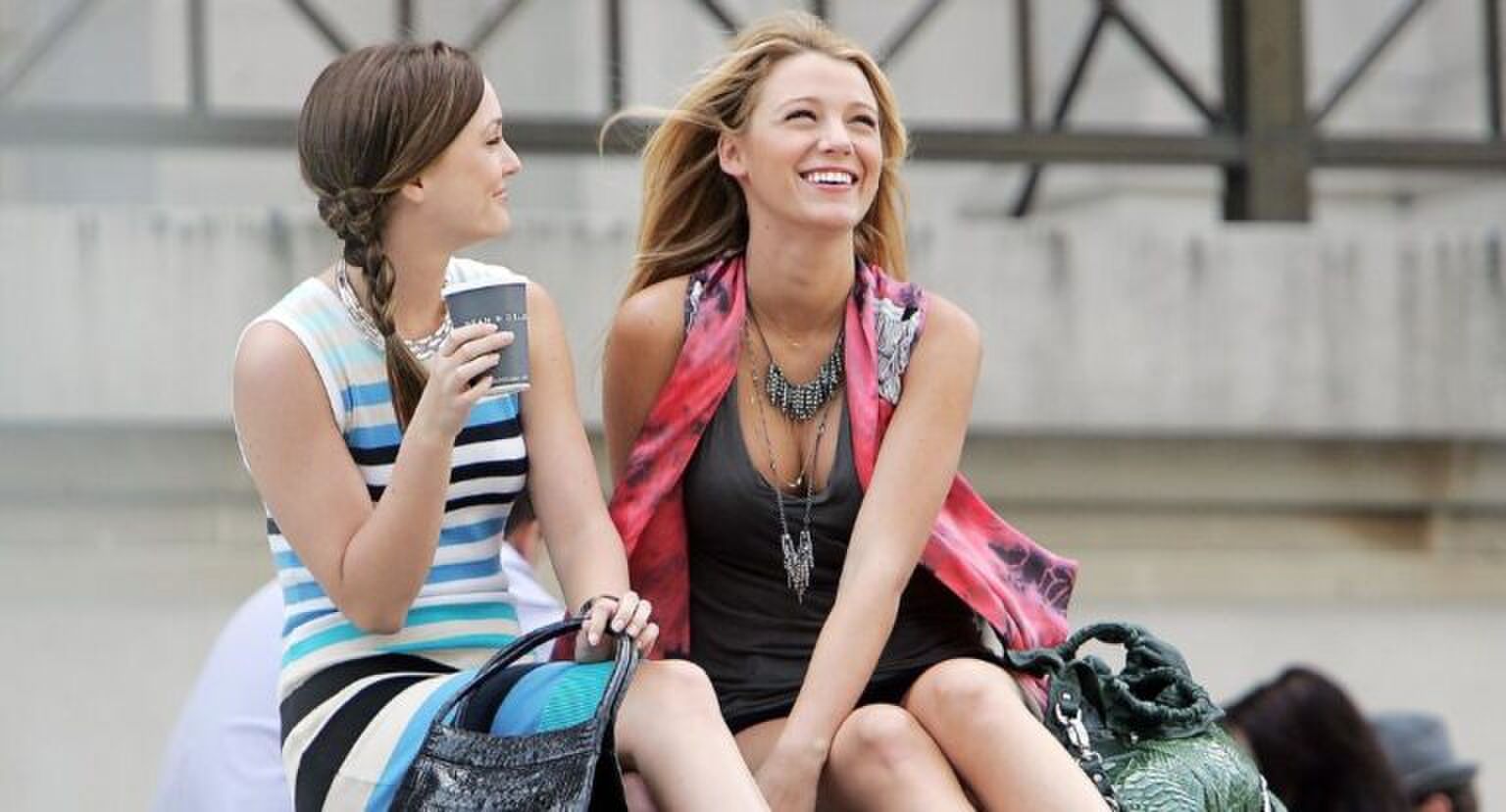 Sc&egrave;ne uit Gossip Girl waar Blair en Serena op een trap zitten en samen lachen.