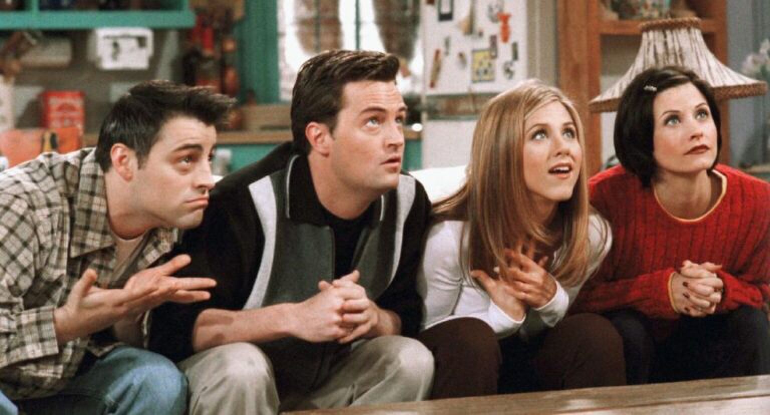 Sc&egrave;ne uit Friends waarin Joey, Chandler, Rachel en Monica op de bank zitten en omhoog kijken.