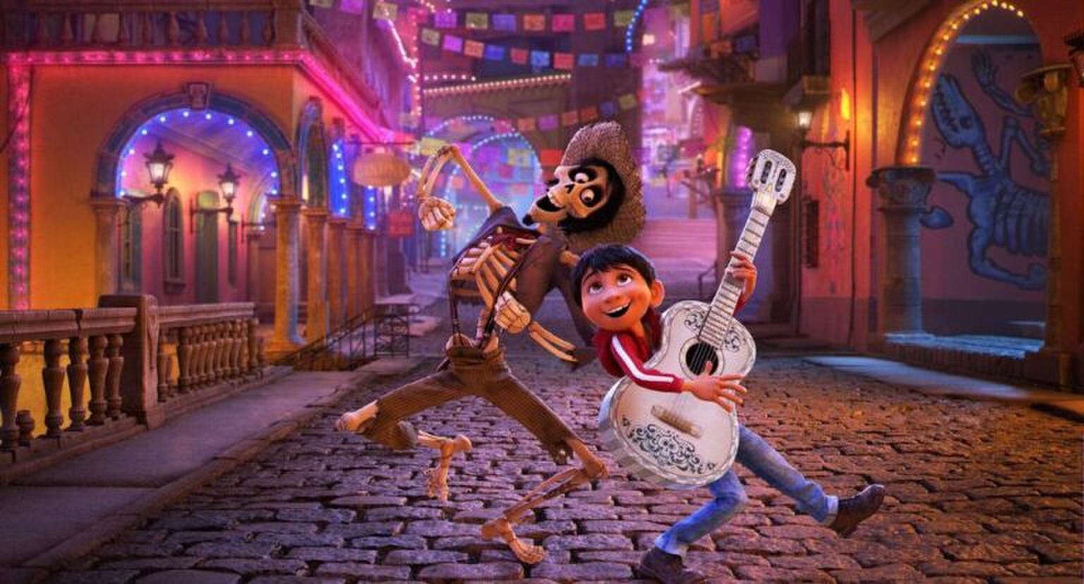 Sc&egrave;ne uit Coco waarin Miguel en H&eacute;ctor blij over straat lopen terwijl Miguel gitaar speelt.