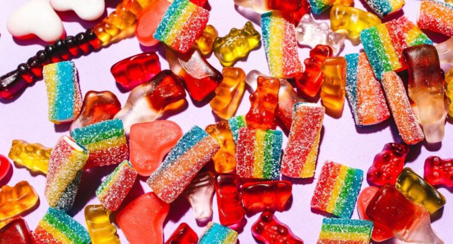 Verschillende soorten snoepjes op een roze achtergrond.