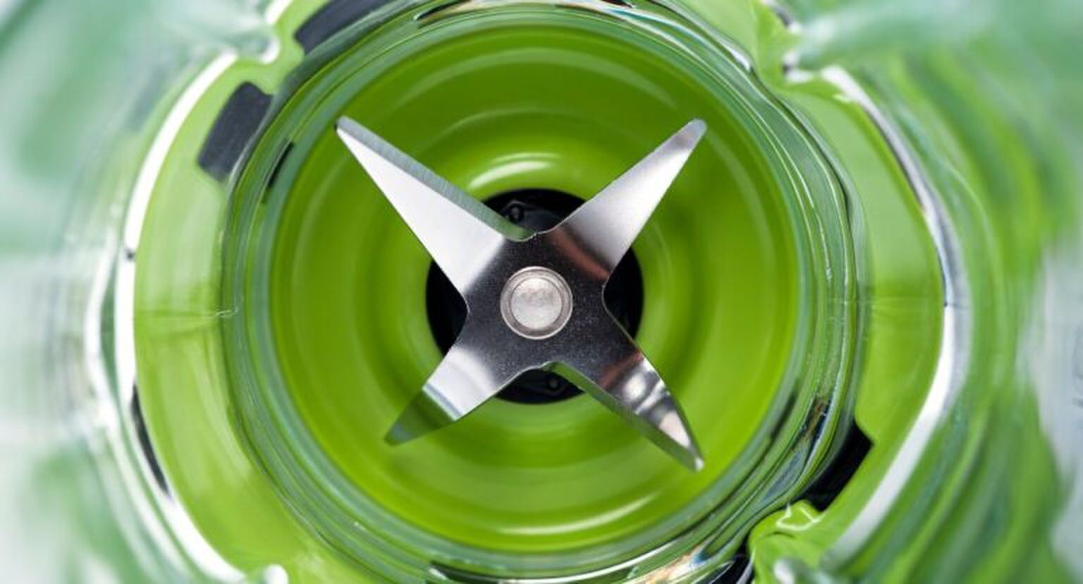 Een blender met groene inhoud.