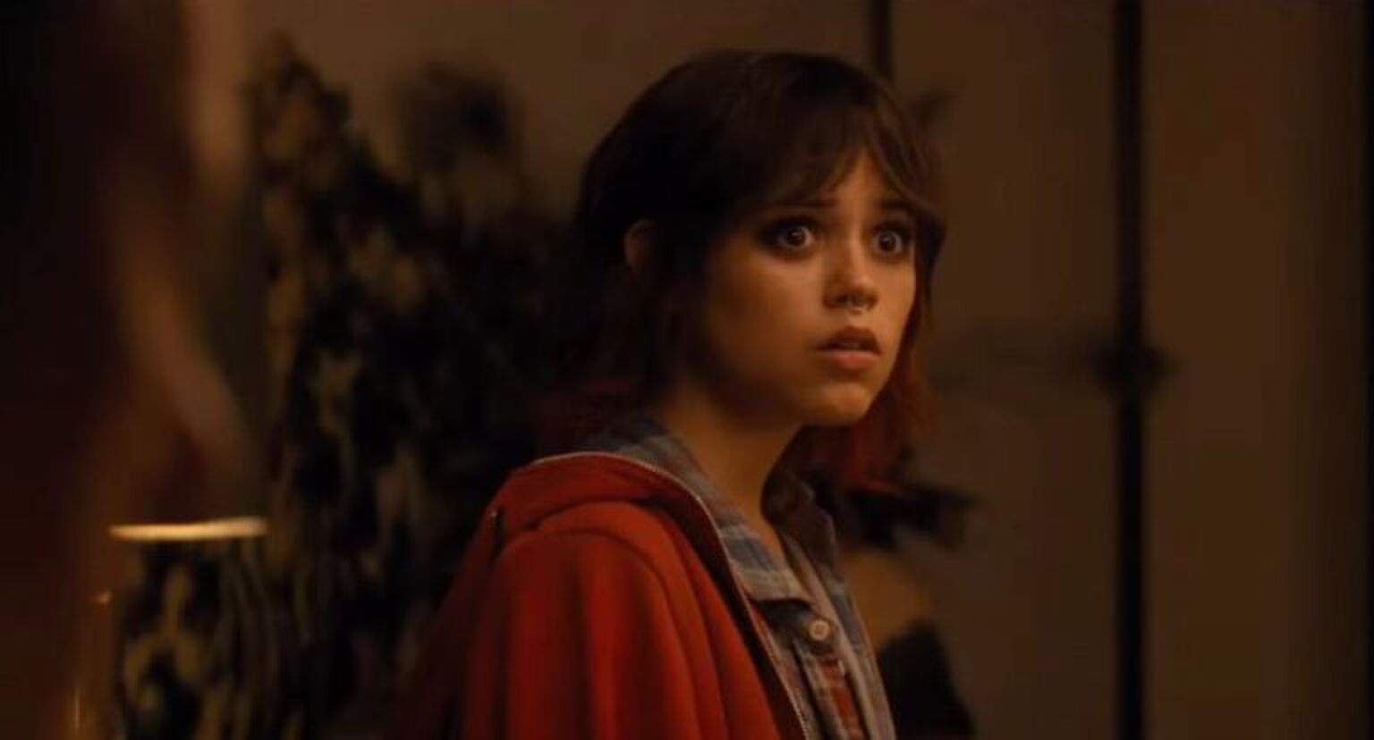 Meisje met donker haar kijkt verschrikt.