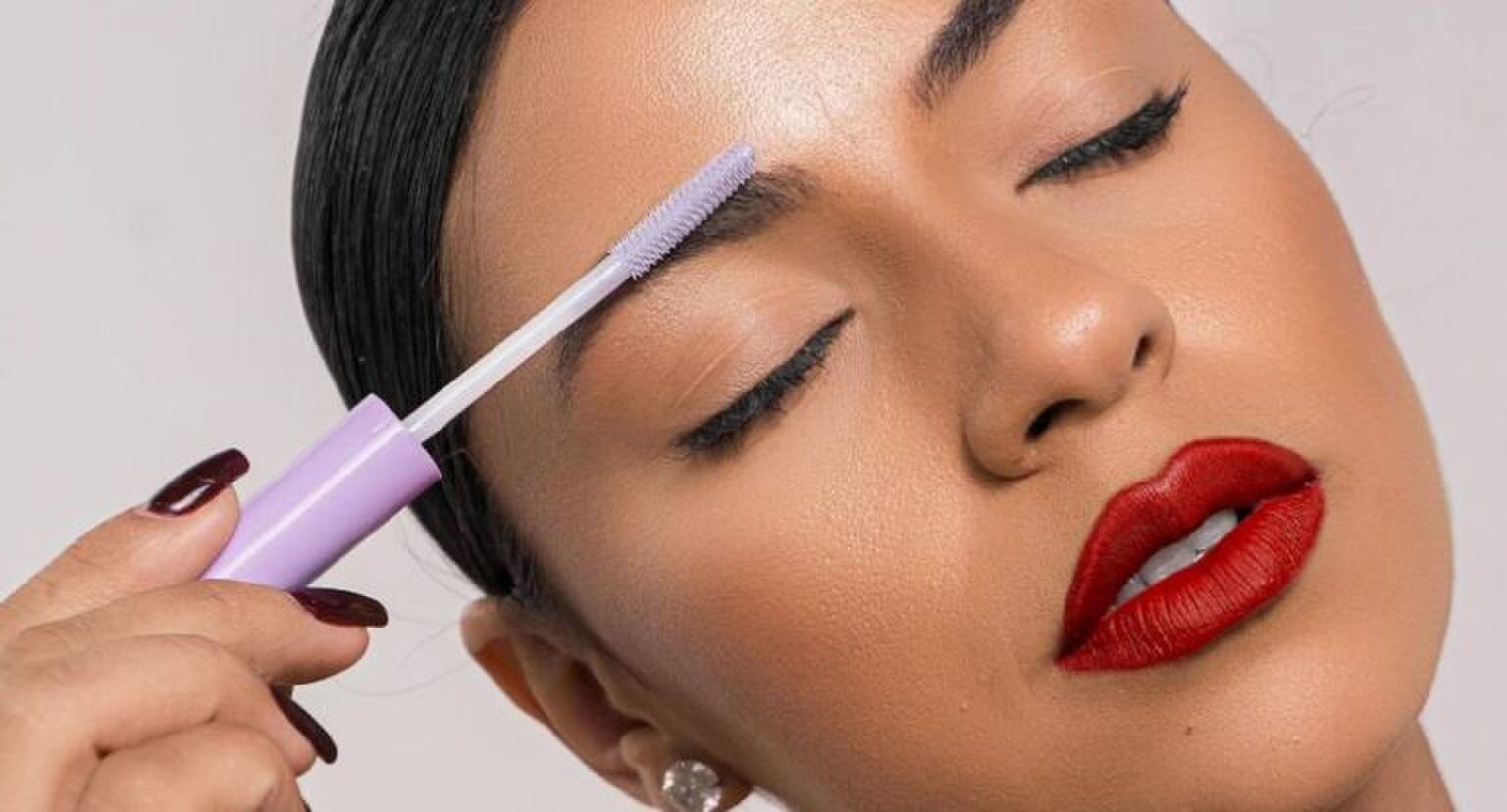 Een vrouw die haar wenkbrauwen met een wenkbrauwgel styled.