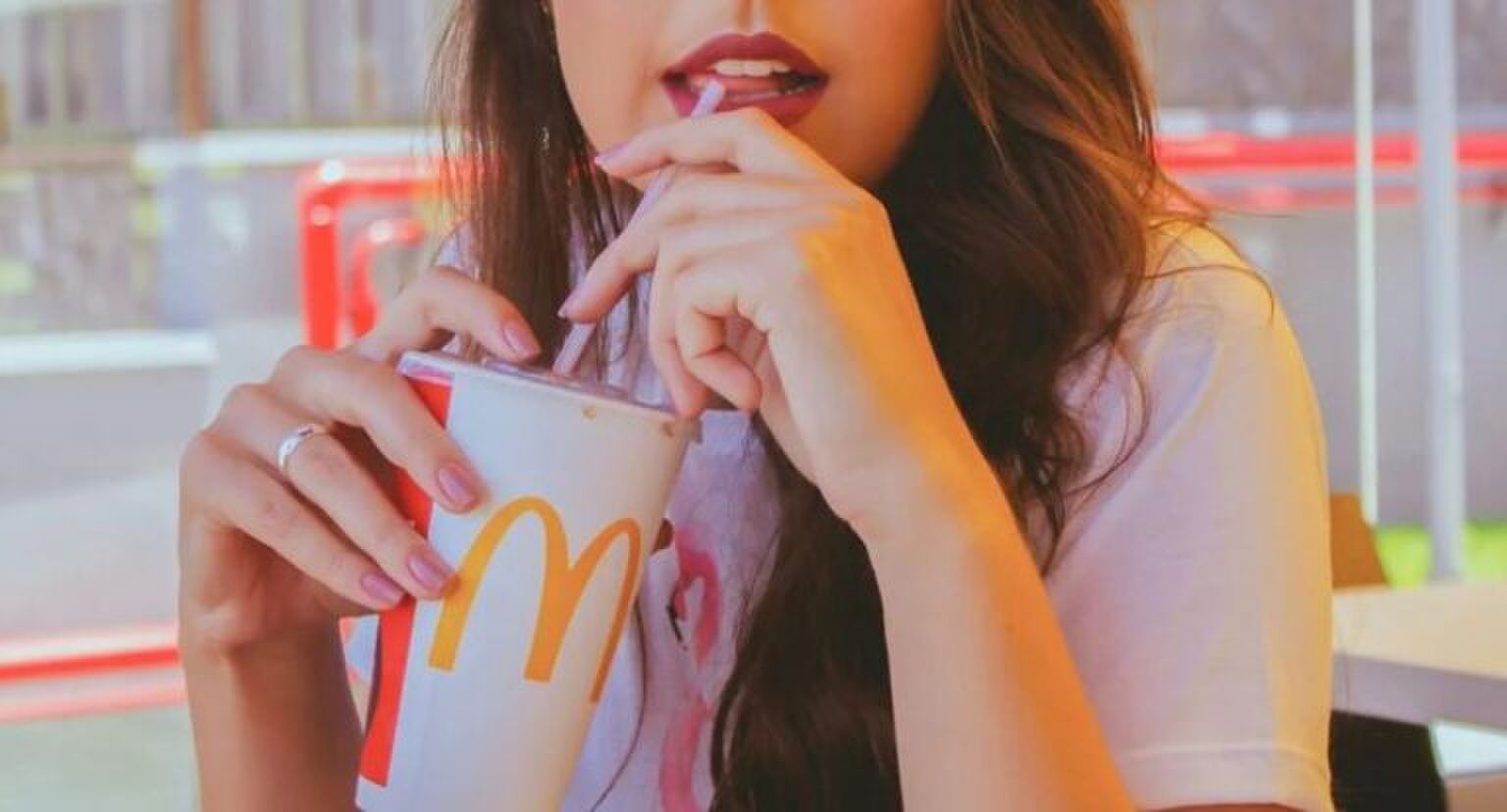 Vrouw zit aan tafel bij de McDonald's.