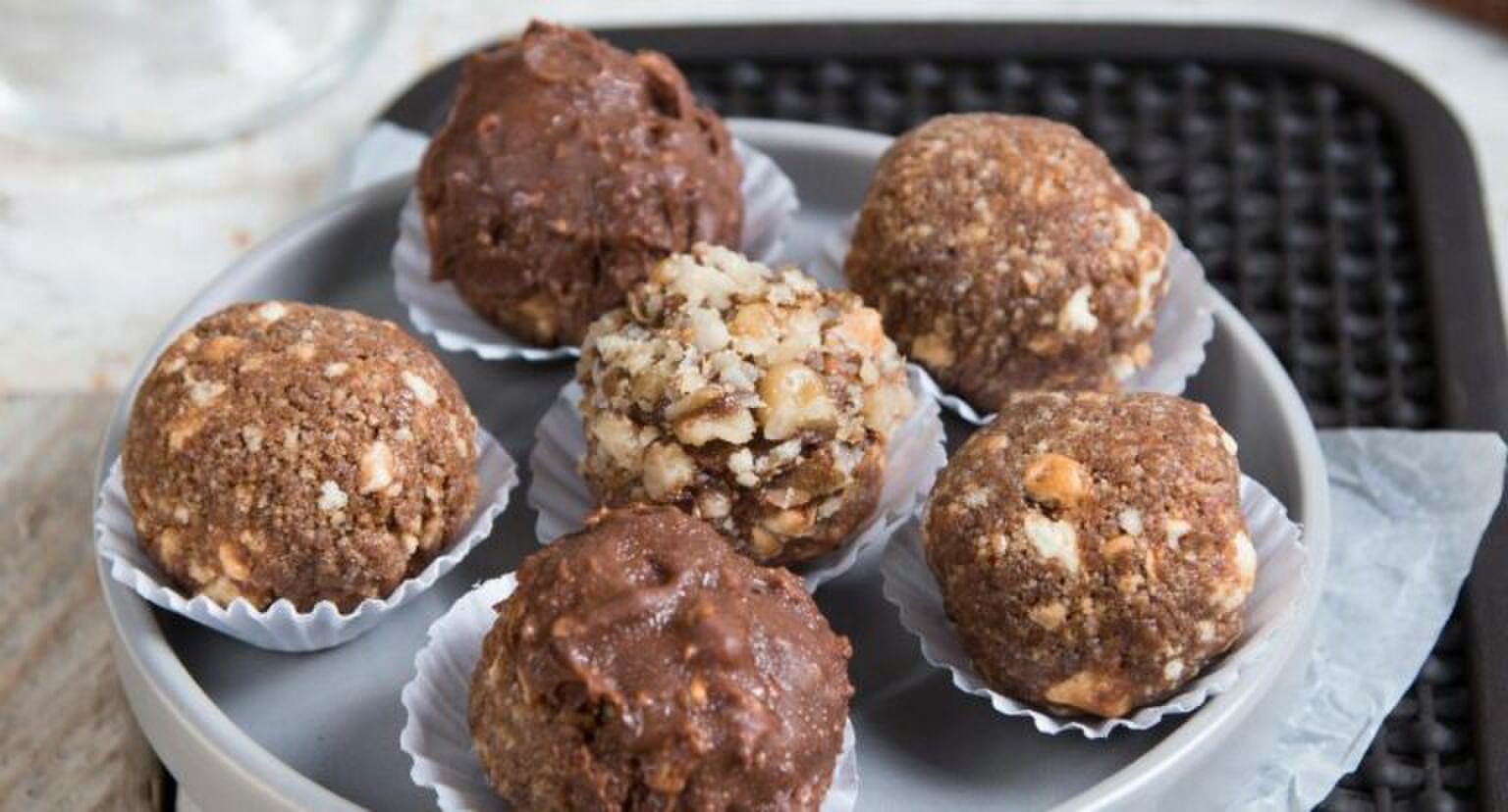 Chocolade balletjes op een zwart schaaltje.