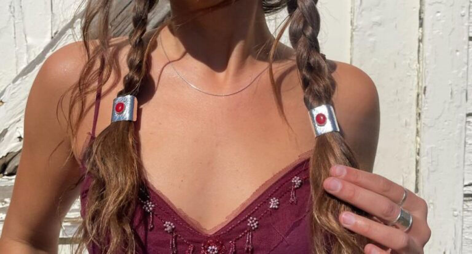 Een vrouw met twee vlechtjes in en haarsieraden als elastiekjes.