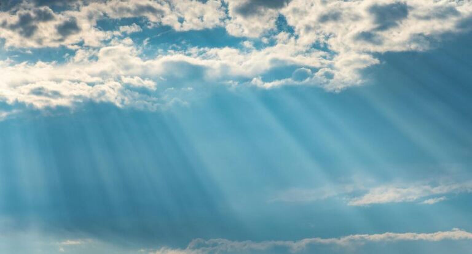 Het zonnetje schijnt door de wolken door.