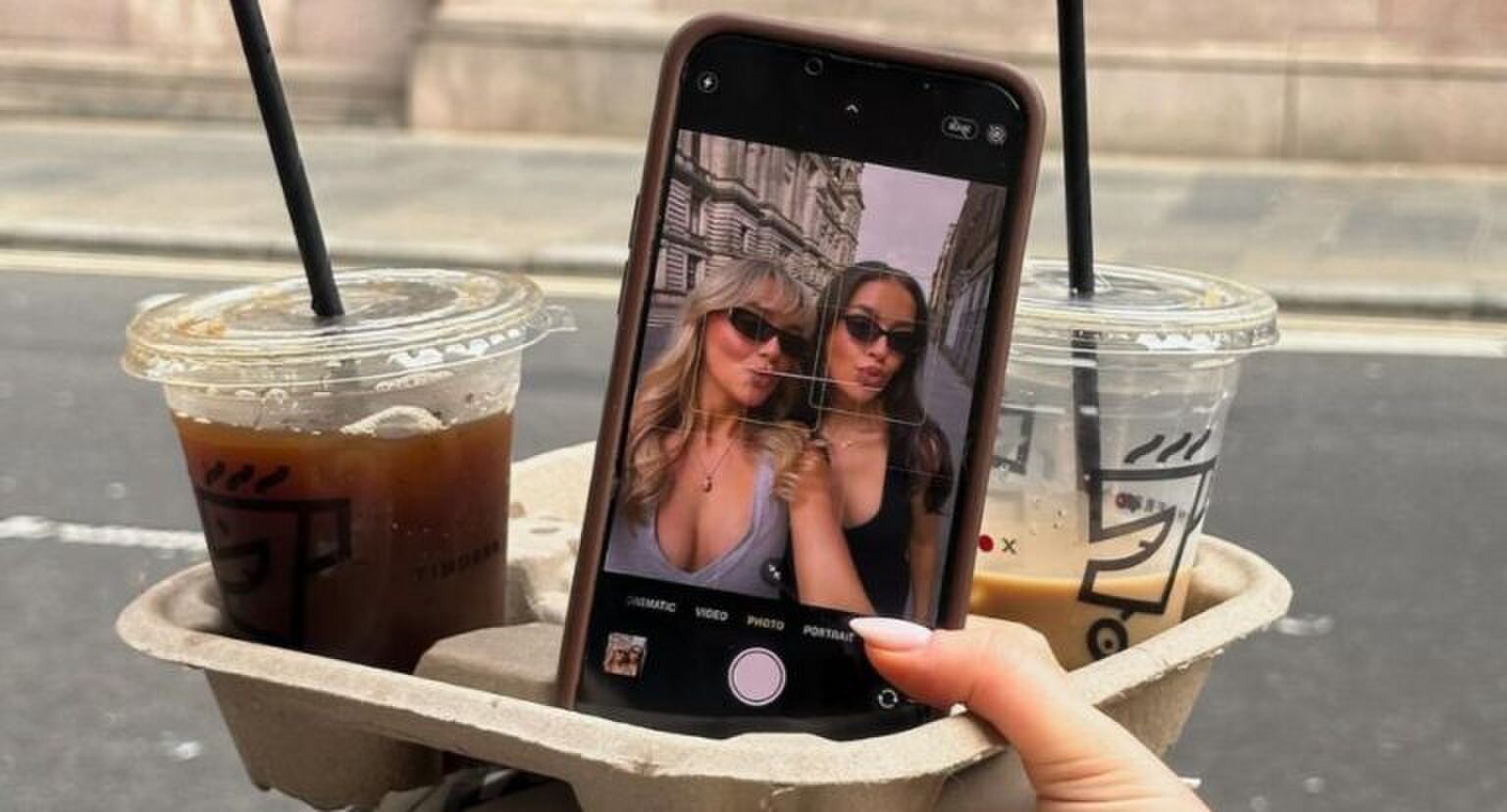 Selfie van twee jonge vrouwen met ijskoffie.