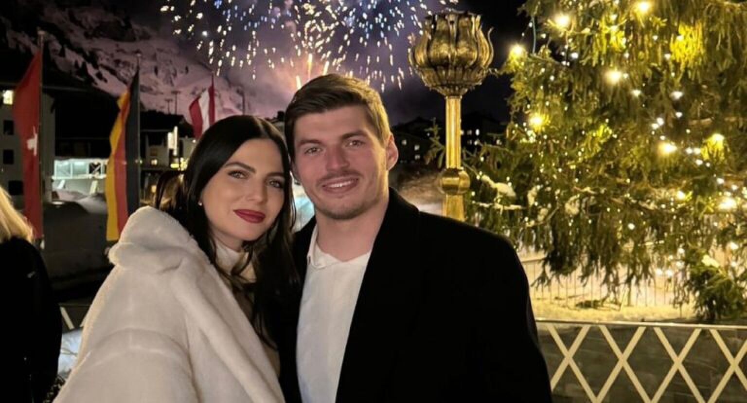 Foto van Kelly Piquet en Max Verstappen, voor vuurwerk en een kerstboom.
