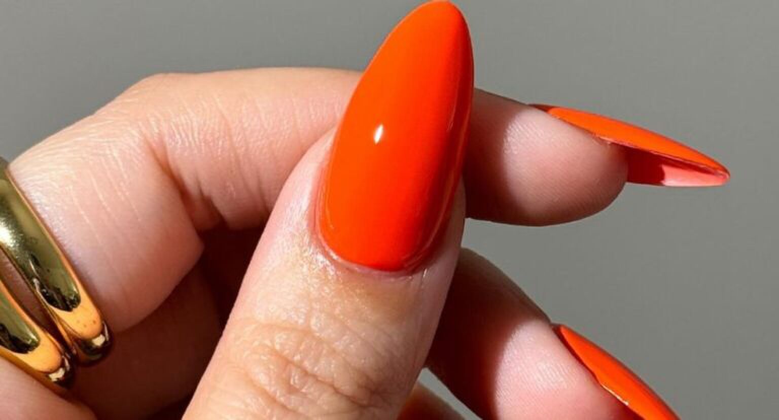 hand met oranje nagellook