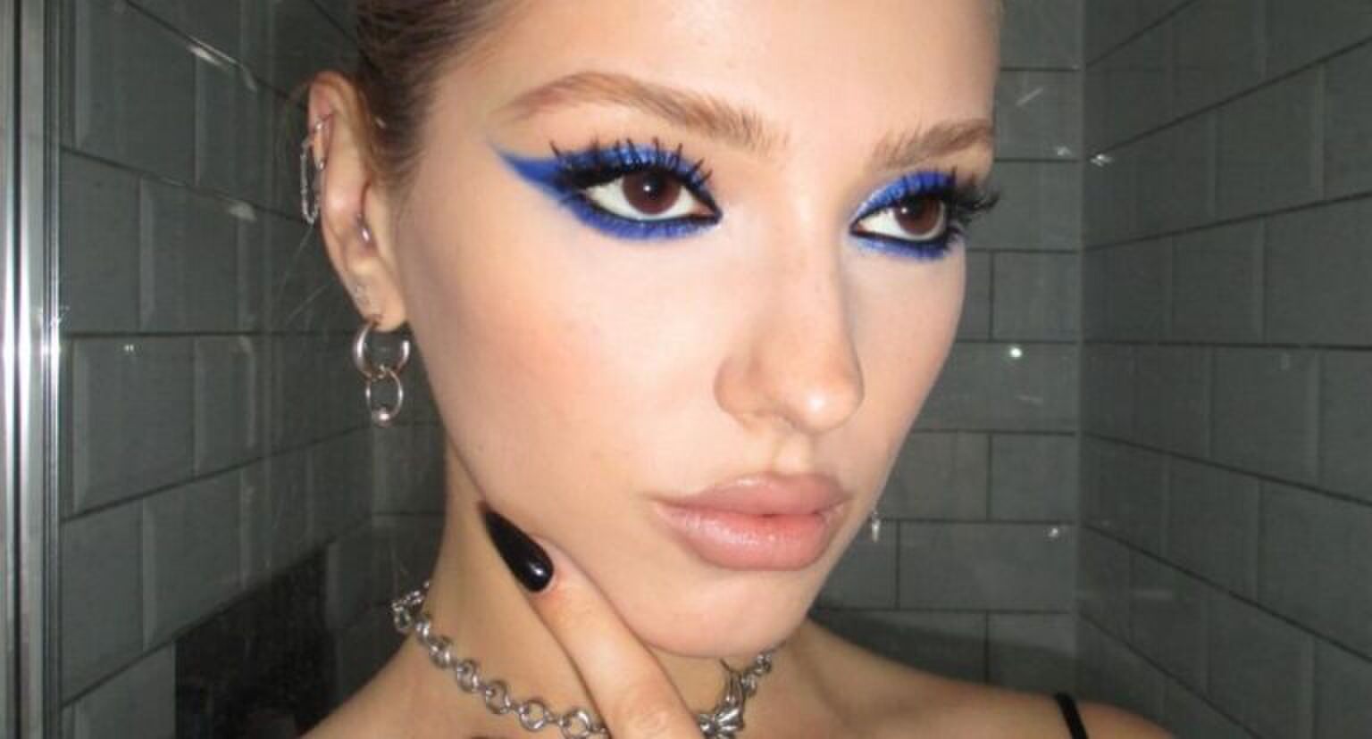 Danielle Marcan met met een party girl make-up look. Blauwe, glitterige oogschaduw en opvallende wimpers.