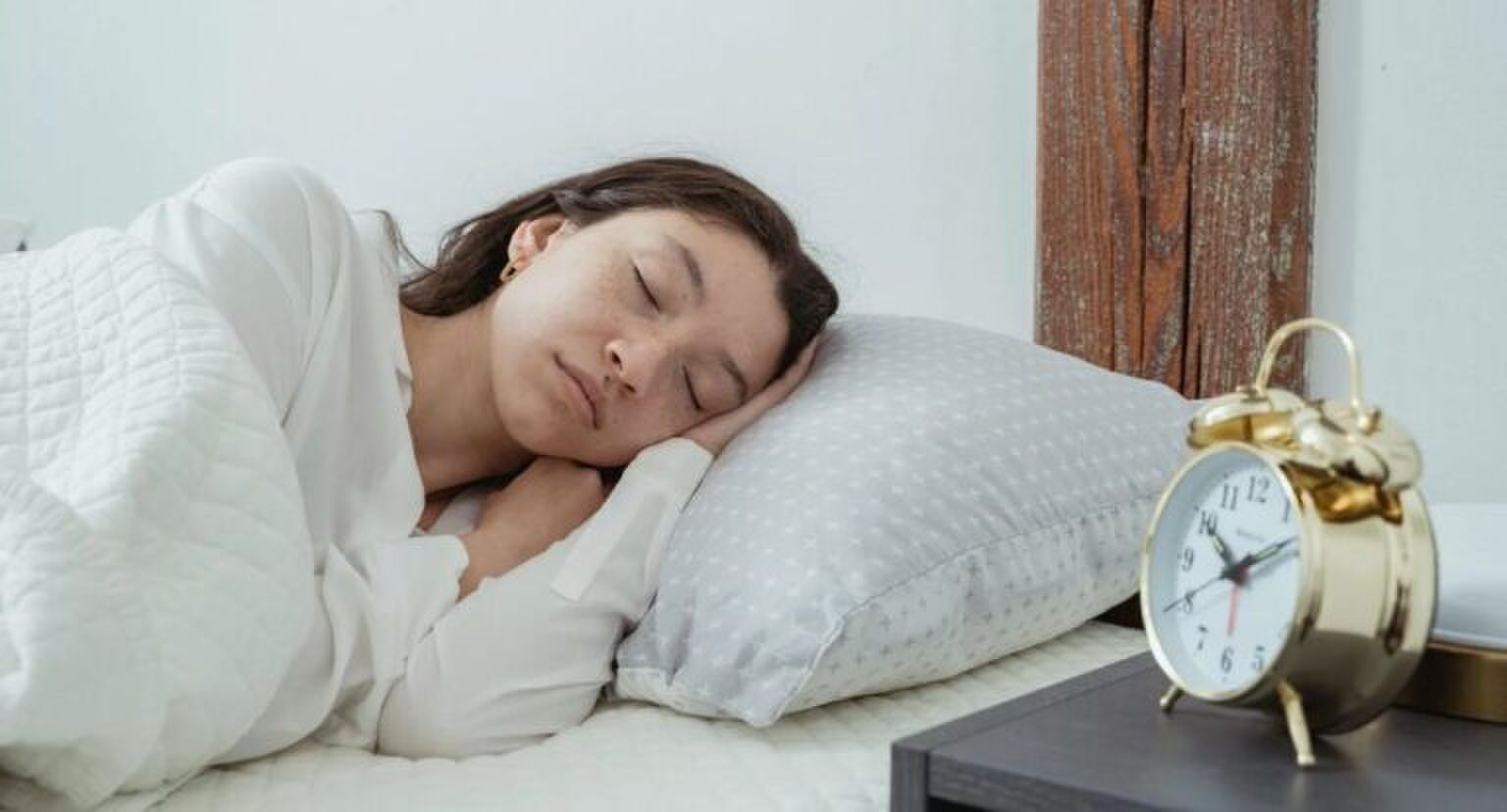 Een meisje die in bed ligt te slapen.