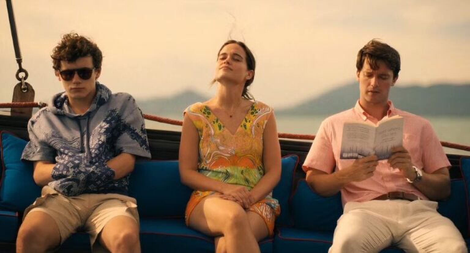 Sc&egrave;ne uit The White Lotus waar 3 personages op een boot zitten.