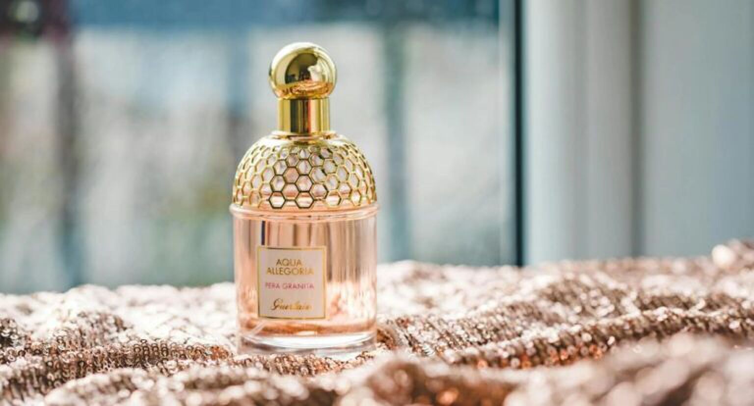 Roze parfum op een roze kleedje.