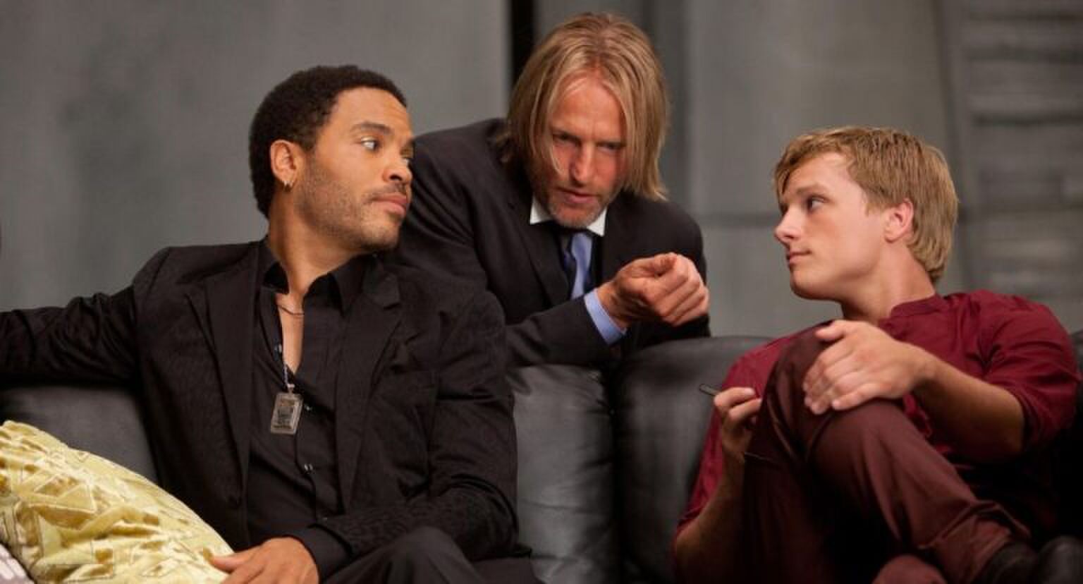 Haymitch, Peeta en Cinna zijn druk in overleg.