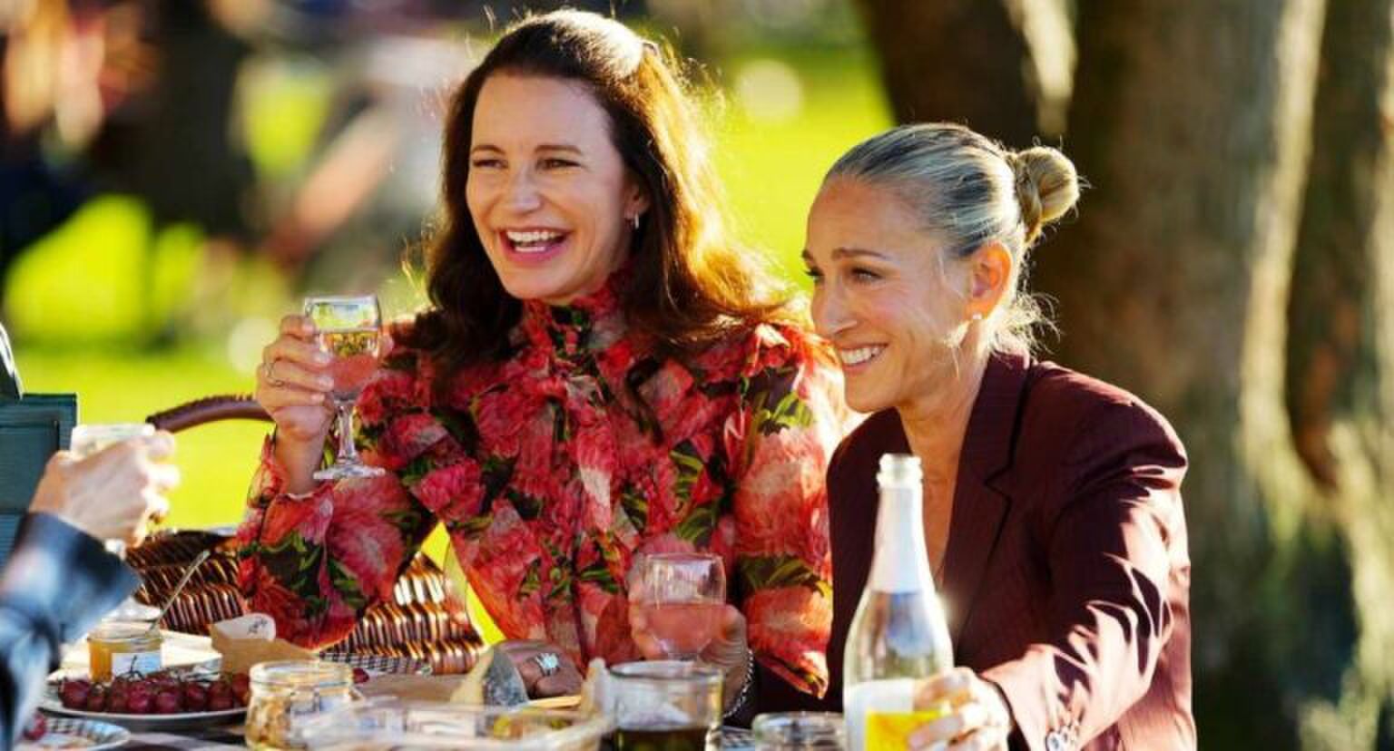 Charlotte en Carrie zitten samen aan tafel te lachen.