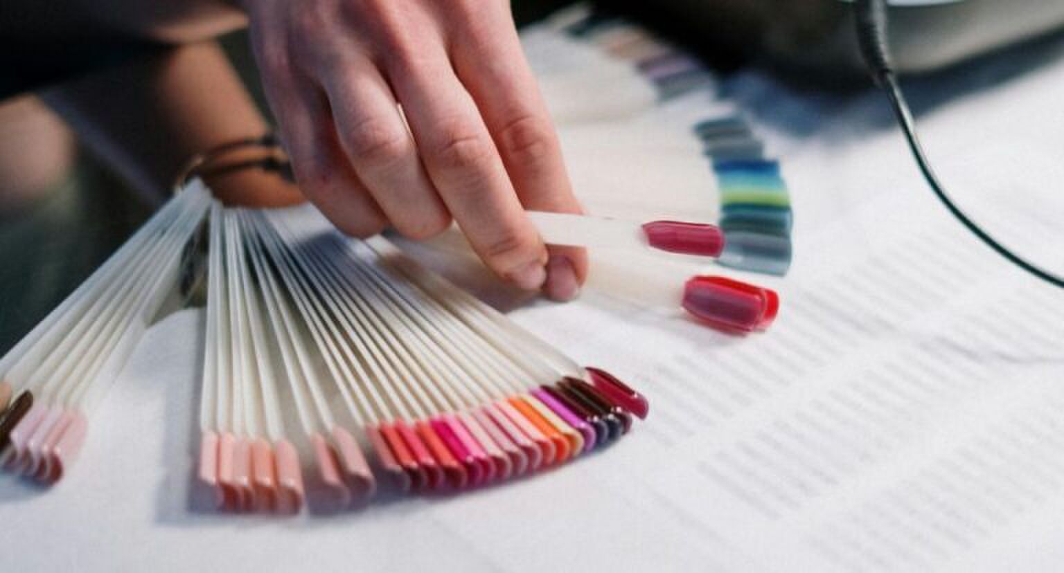 Een kleurpalet van verschillende kleuren nagels bij de nagelsalon.