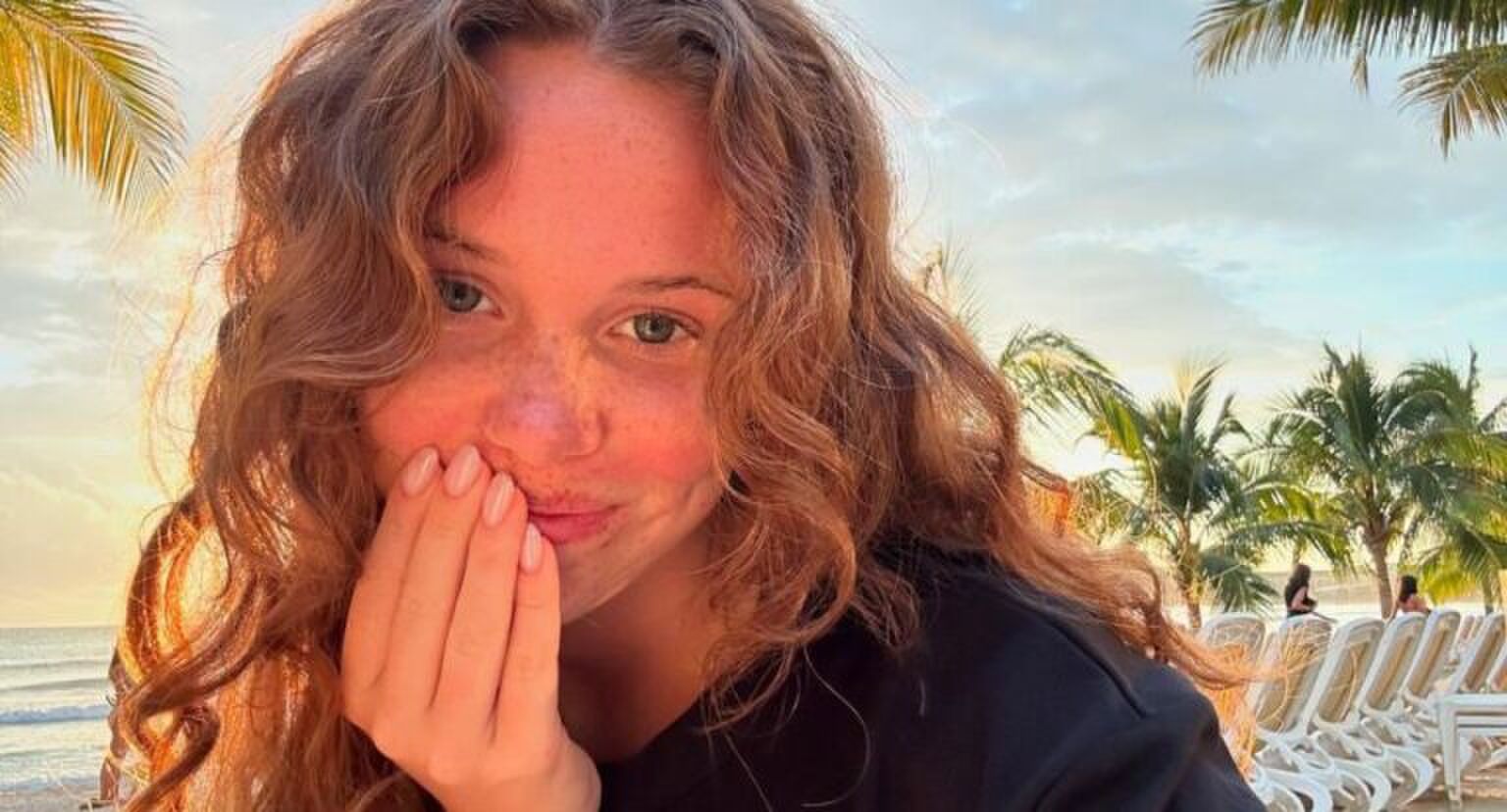 Meisje met krullen op het strand.