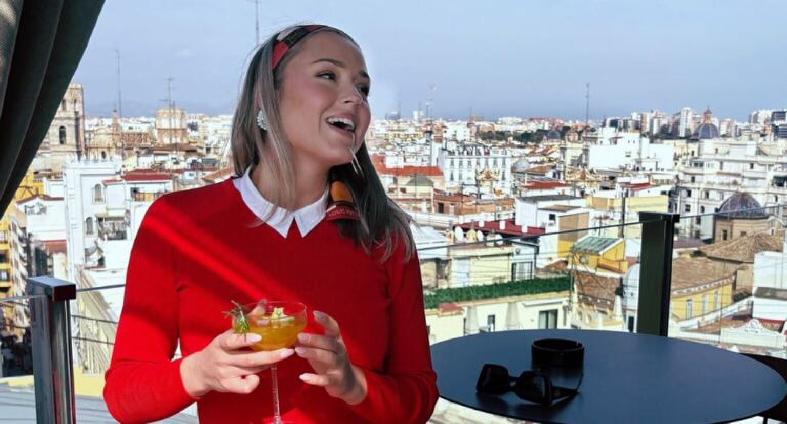 Beate in een restaurant met een drankje in haar hand