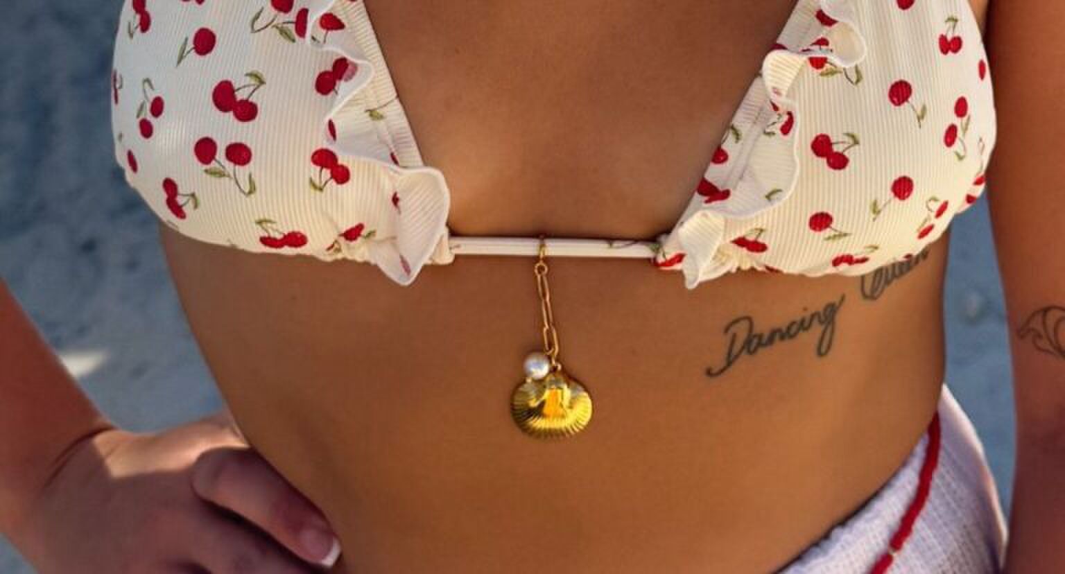 Een vrouw in bikini met een bikini charm aan de bikini.