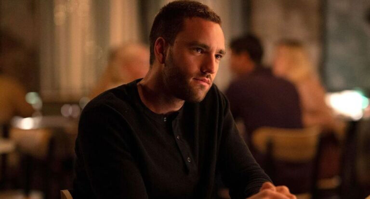 Een man zit aan tafel in een restaurant.