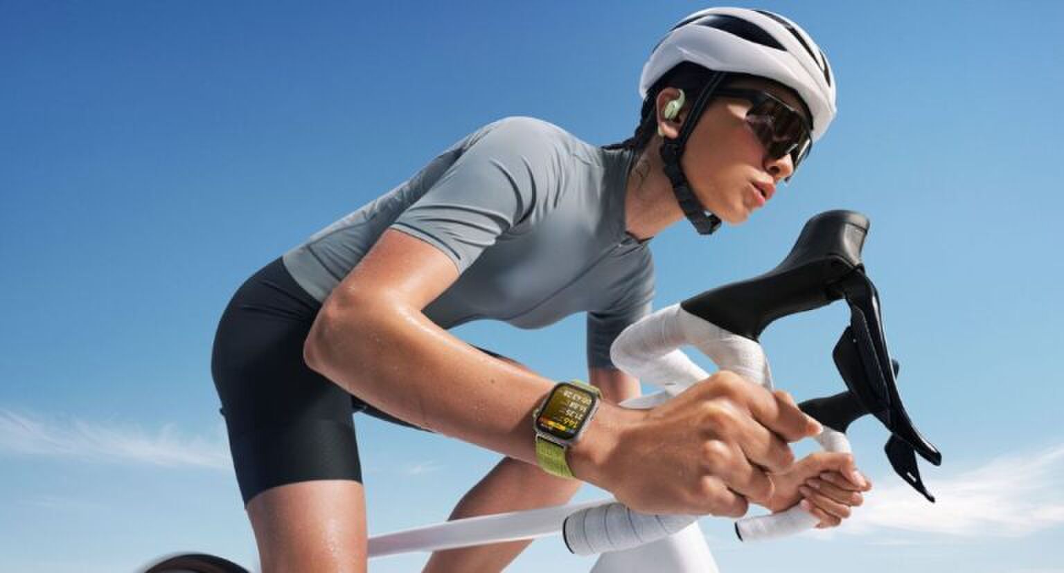 Een jonge vrouw fietst, terwijl haar horloge haar lichaamsfuncties bijhoudt.