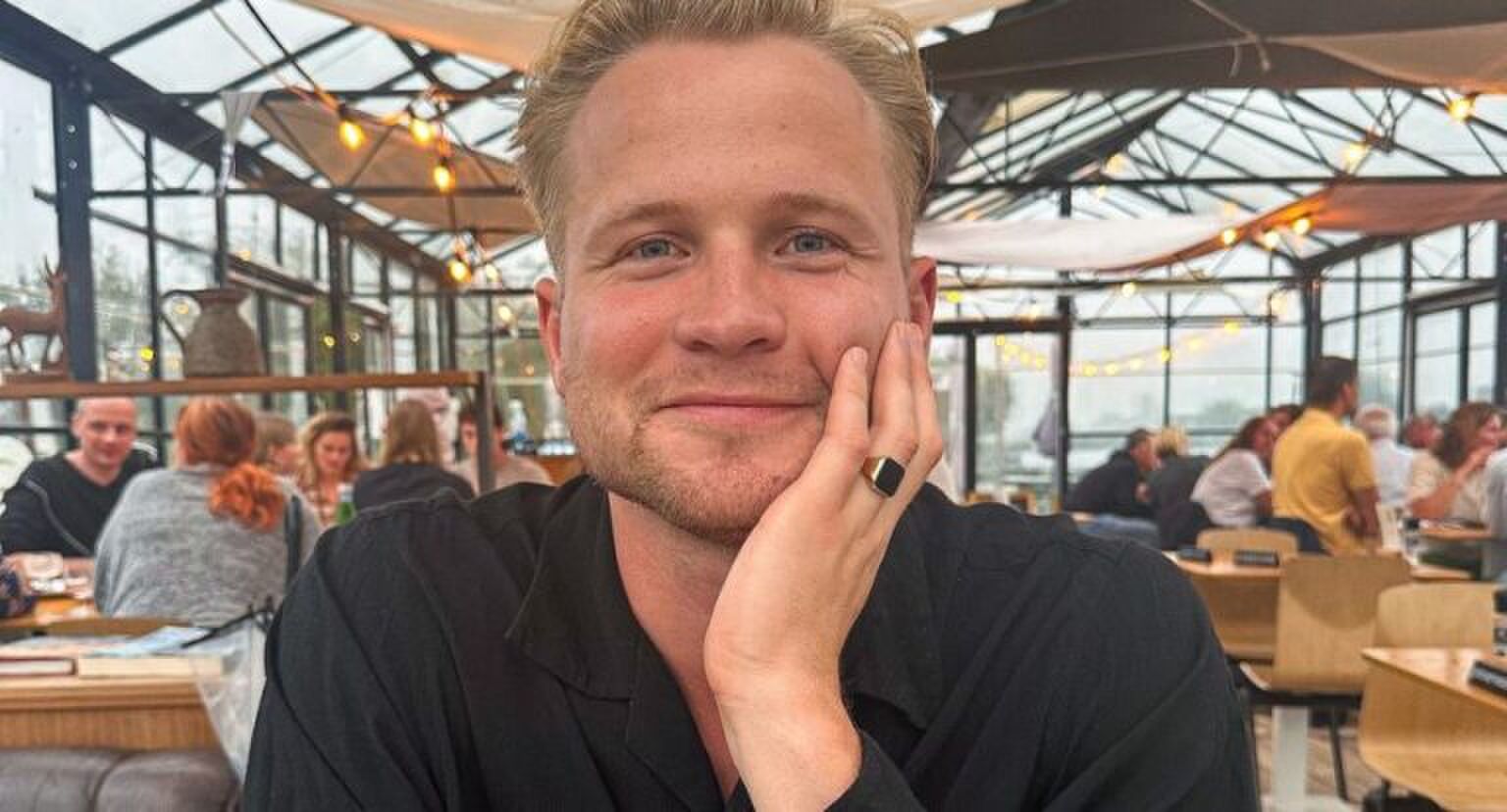 Man kijkt glimlachend in de camera.