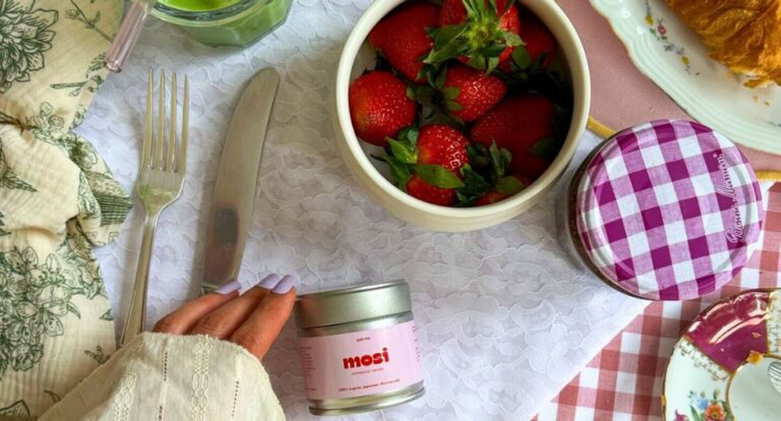 Een gedekte tafel met een ontbijtje en een matchapotje.