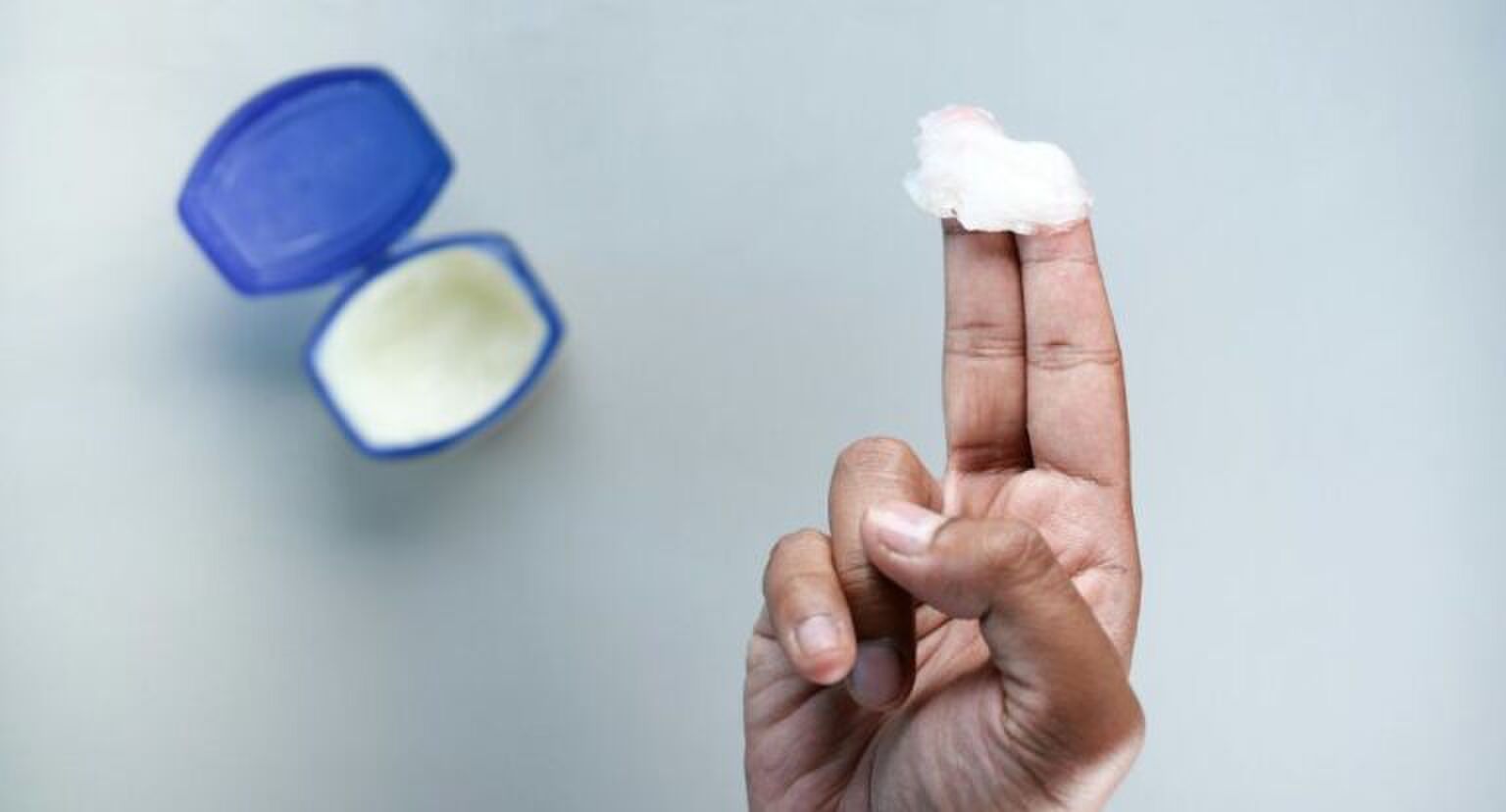 Een hand met een klodder vaseline op de vingers.