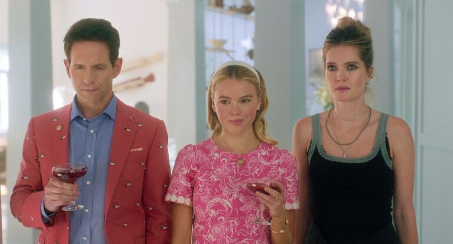 Twee vrouwen en een man kijken langs de camera.