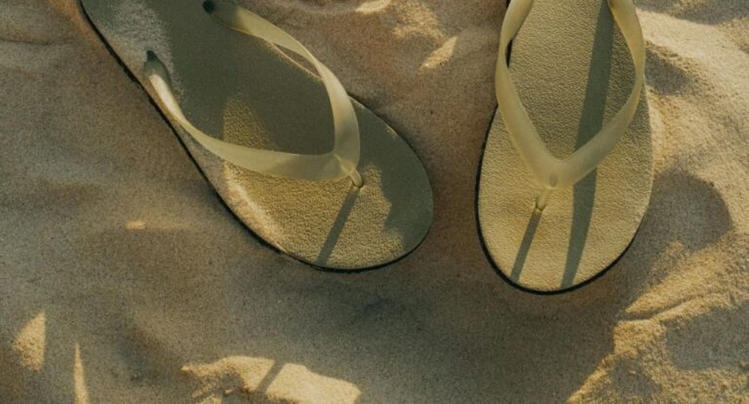 Slippers in het zand.