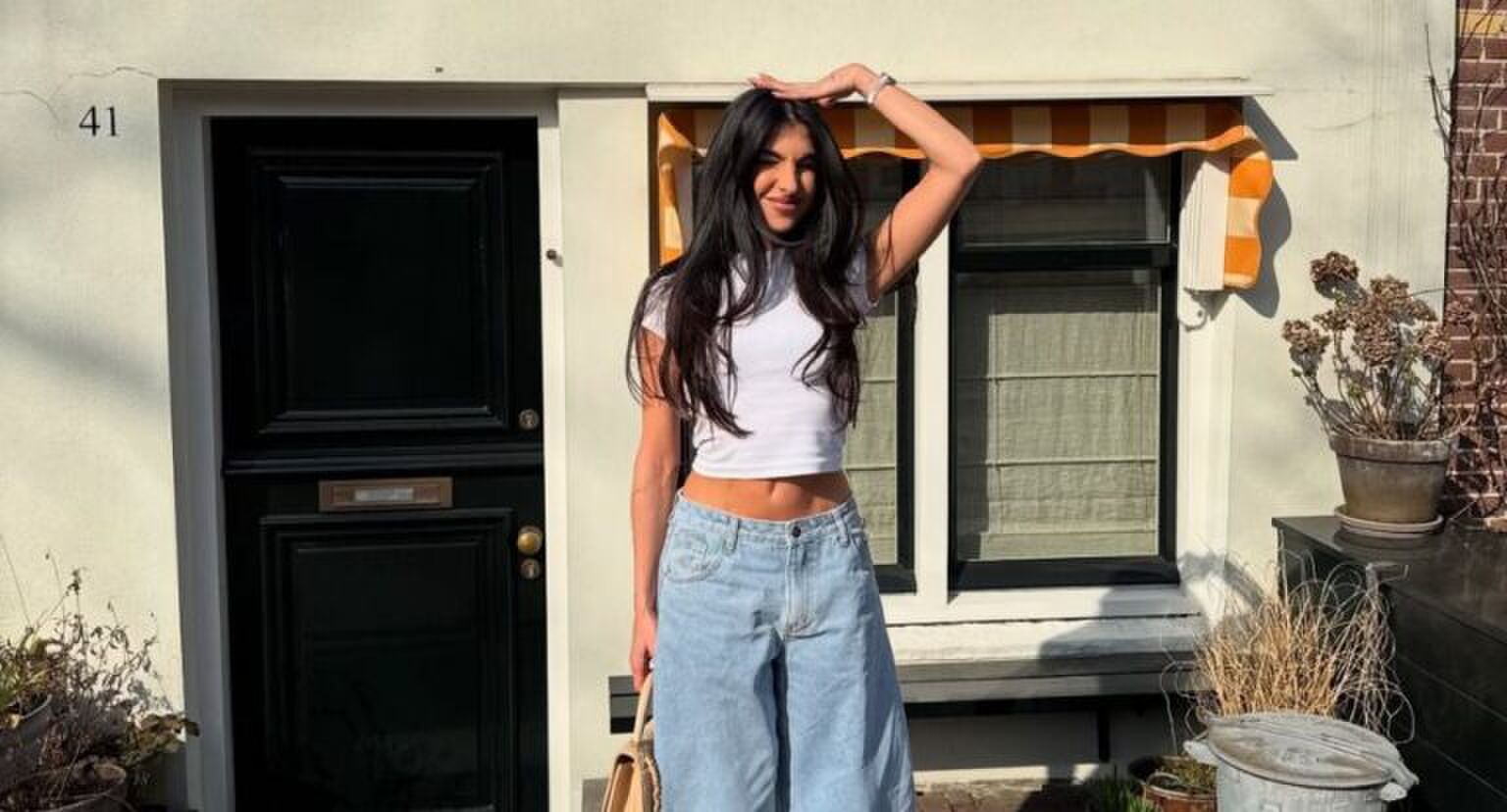 Anna Nooshin staat voor een huis.