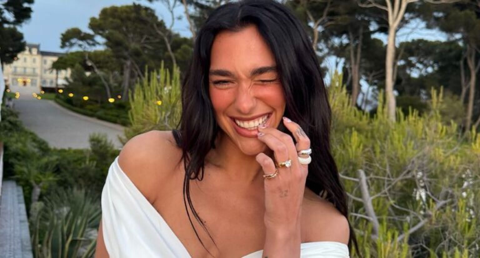 Dua Lipa lacht naar de camera.