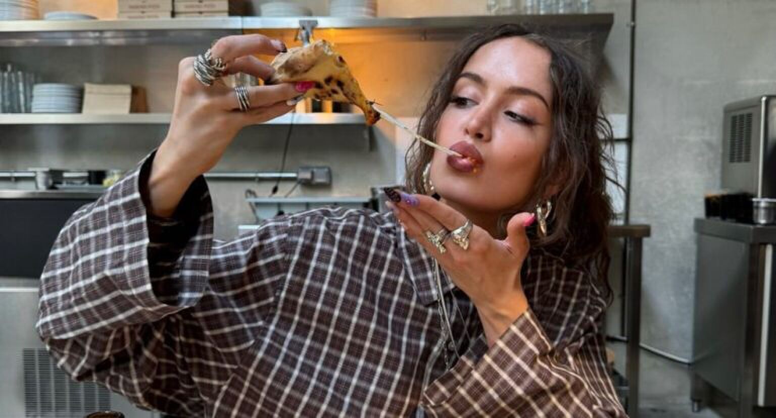 Een vrouw die een pizza aan het eten is.