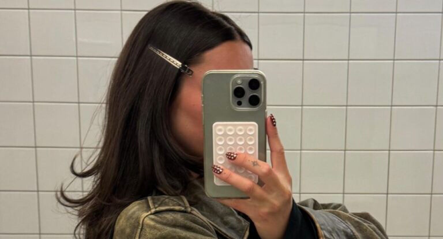 Vrouw maakt een spiegelselfie van haar haar in de spiegel.