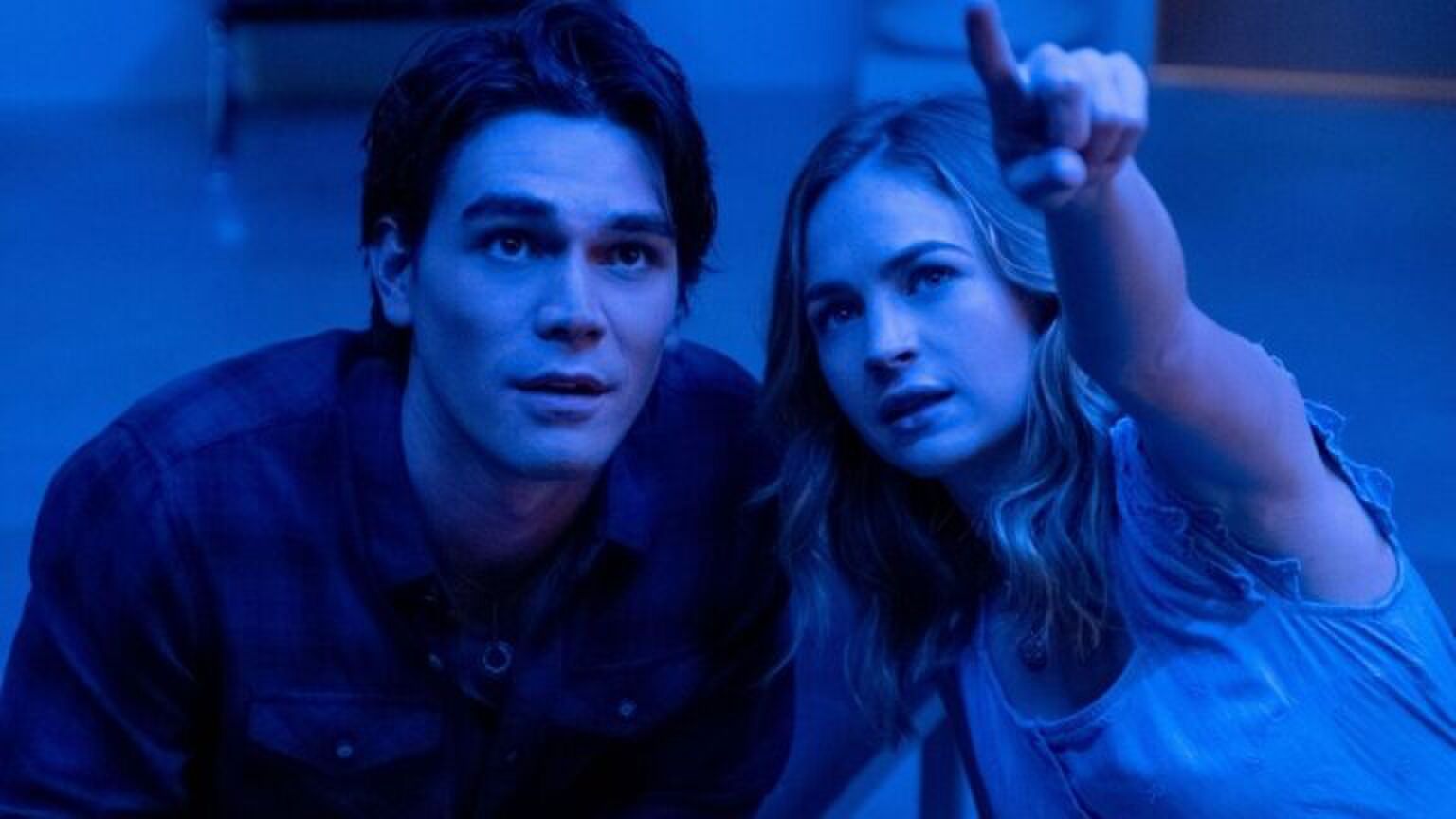 De jonge vrouw wijst naar iets in de verte.