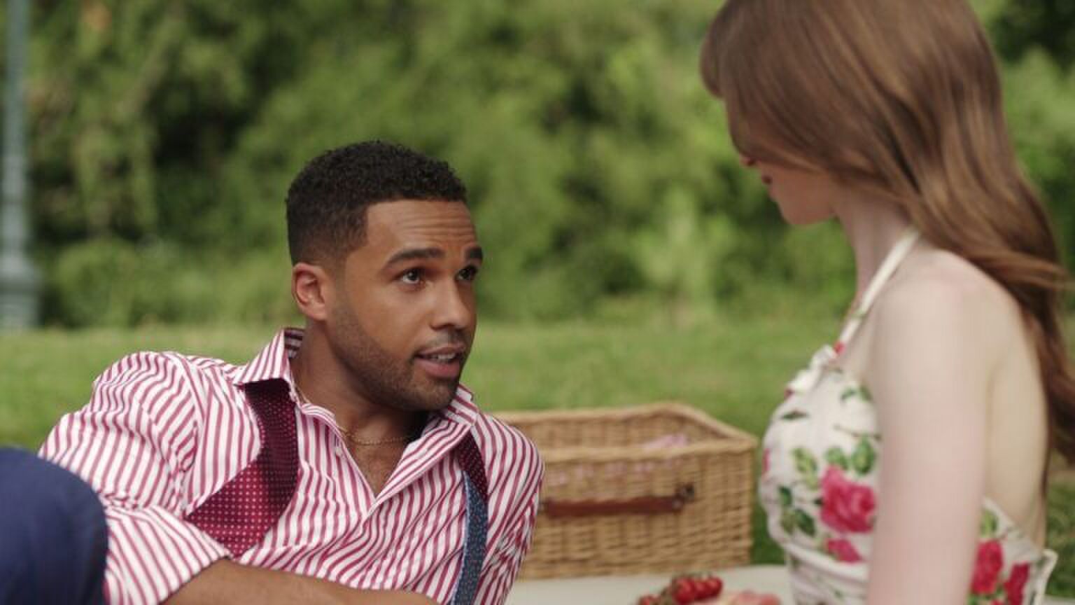 Een koppel zit samen op een picknickkleed.