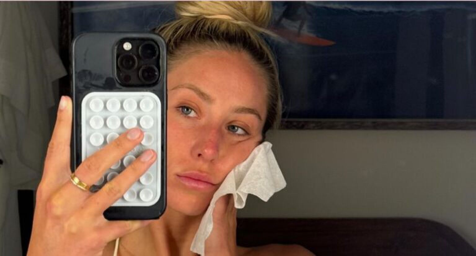 Vrouw wast haar gezicht en maakt een spiegelselfie.