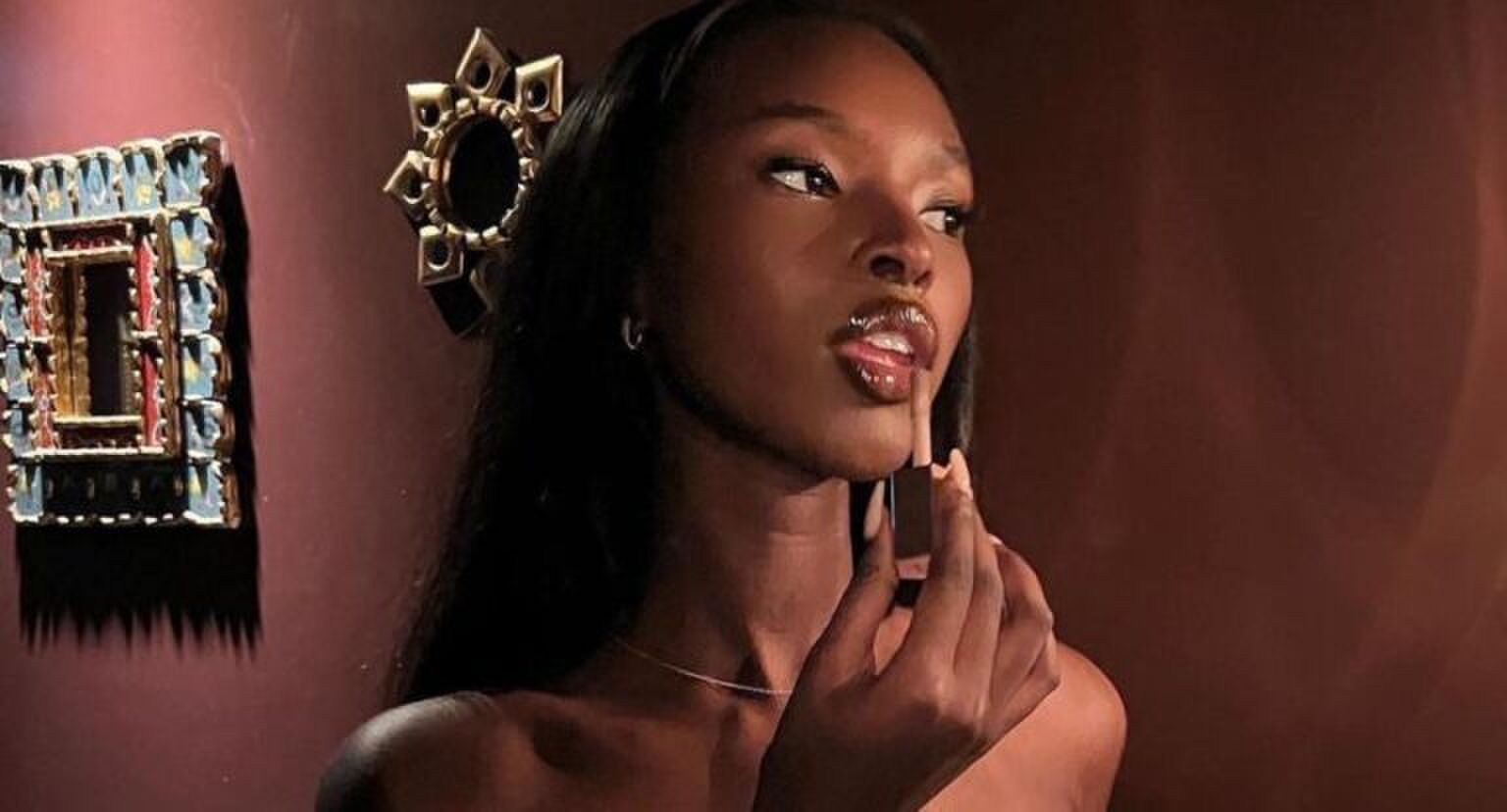 Een vrouw die lipgloss aanbrengt.