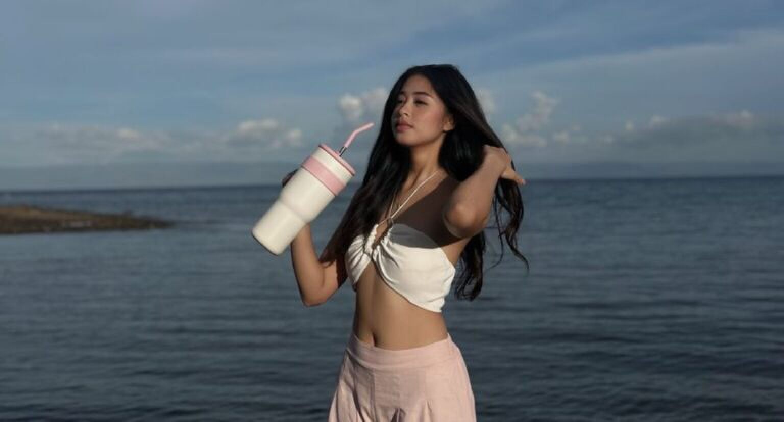 Een vrouw die een waterfles vasthoudt.