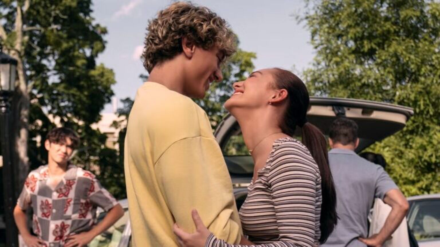 Een koppel lacht verliefd naar elkaar.