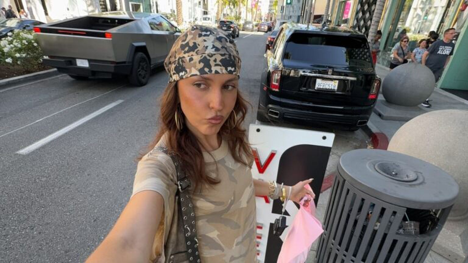 Een meisje maakt een selfie met een bandana om haar hoofd geknoopt.